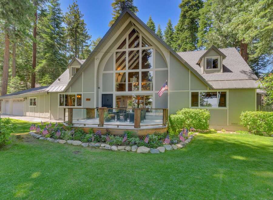 Nestled amidst towering pine trees, this charming home offers a picturesque setting with a spacious deck perfect for outdoor entertaining.