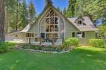 Nestled amidst towering pine trees, this charming home offers a picturesque setting with a spacious deck perfect for outdoor entertaining.