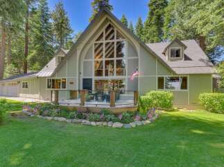 Nestled amidst towering pine trees, this charming home offers a picturesque setting with a spacious deck perfect for outdoor entertaining.