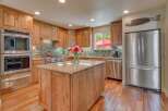 This spacious kitchen boasts beautiful natural wood cabinetry and a large granite-topped island, perfect for meal preparation and casual dining.