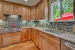 This beautifully appointed kitchen features custom wood cabinetry and a stunning mosaic tile backsplash.