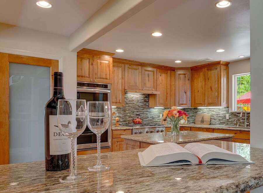 Experience luxury in this stunning kitchen, featuring custom wood cabinetry and a sleek mosaic tile backsplash.