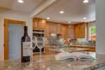 Experience luxury in this stunning kitchen, featuring custom wood cabinetry and a sleek mosaic tile backsplash.