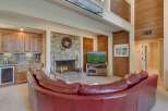 Experience ultimate relaxation in this stunning living room, featuring a cozy stone fireplace and a luxurious curved leather sofa perfect for gathering.
