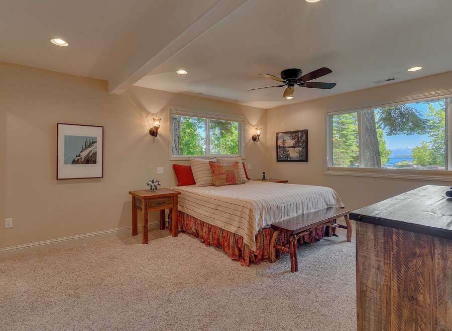 This charming bedroom offers a serene retreat with its comfortable king-size bed, adorned with striped linens and decorative pillows.