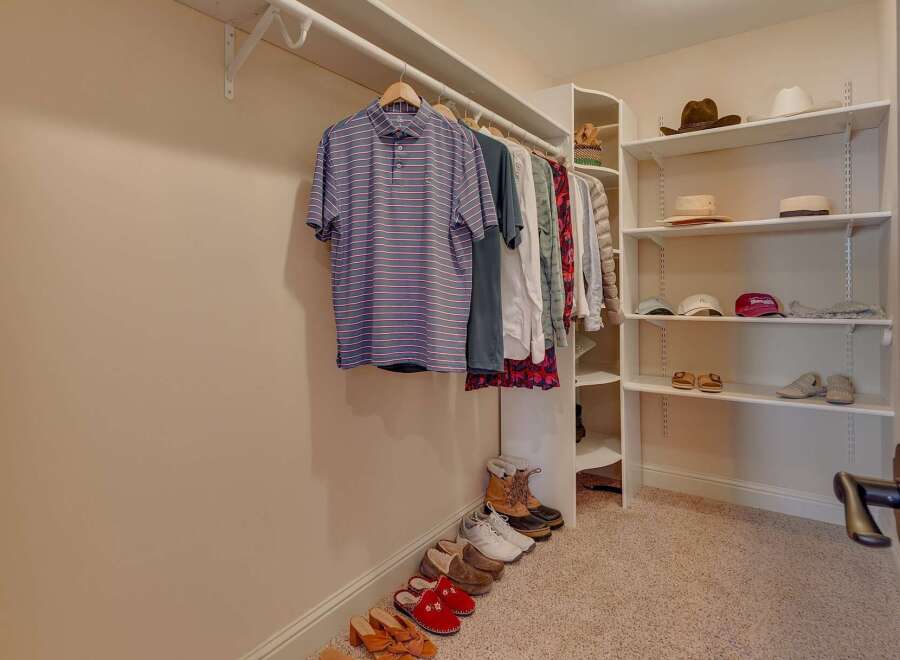 Discover organized living in this spacious walk-in closet, featuring ample hanging space for your wardrobe and well-organized shelving for accessories.
