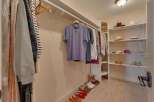 Discover ample storage in this spacious walk-in closet, featuring organized shelving for hats and accessories, along with a well-arranged hanging rod for your apparel.