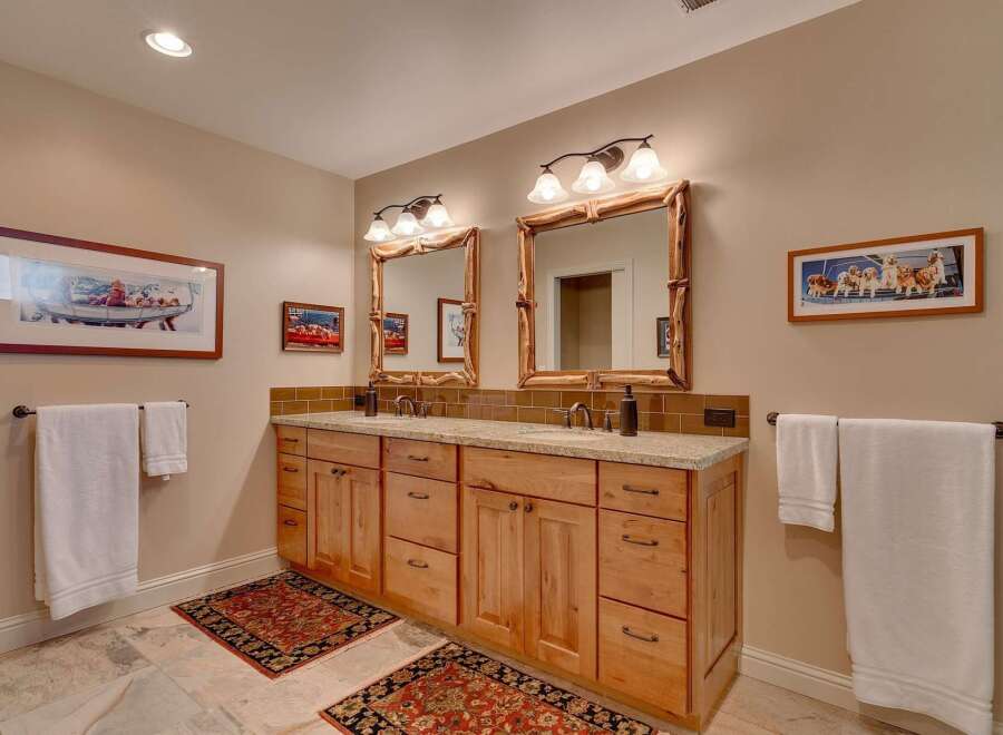 This spacious bathroom features a double vanity with ample storage and granite countertops, perfect for any household.