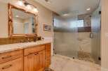 This luxurious bathroom features a spacious walk-in shower with frosted glass doors and elegant tilework.