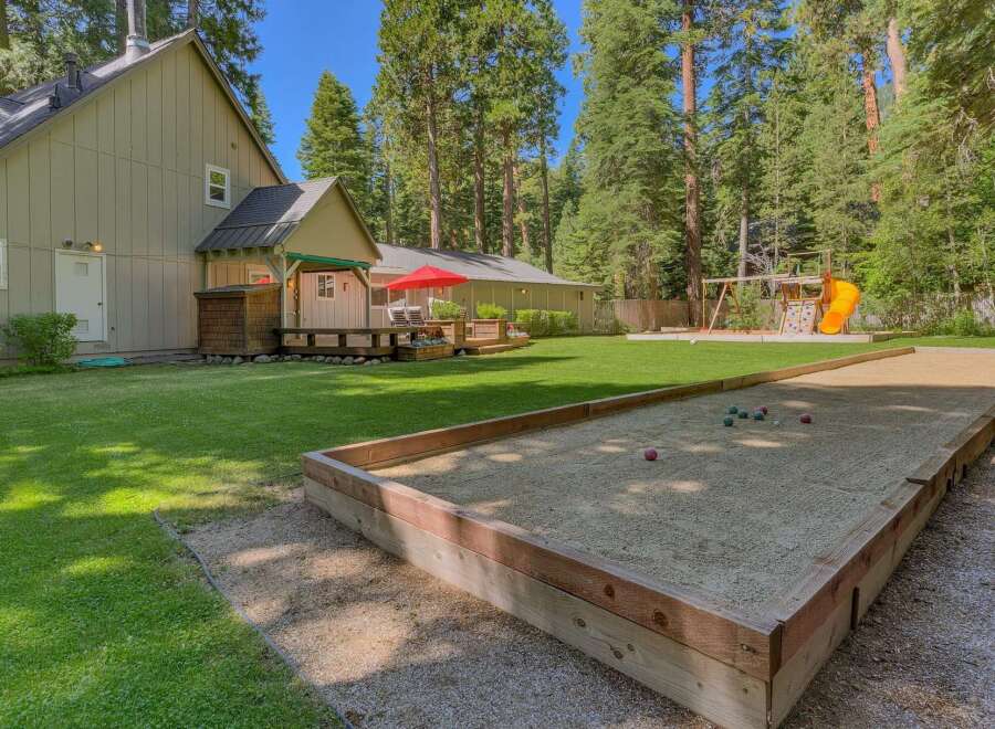 Enjoy outdoor fun in this spacious backyard featuring a bocce ball court and a playground with a slide.