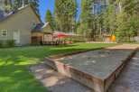 Enjoy outdoor fun in this spacious backyard featuring a bocce ball court and a playground with a slide.