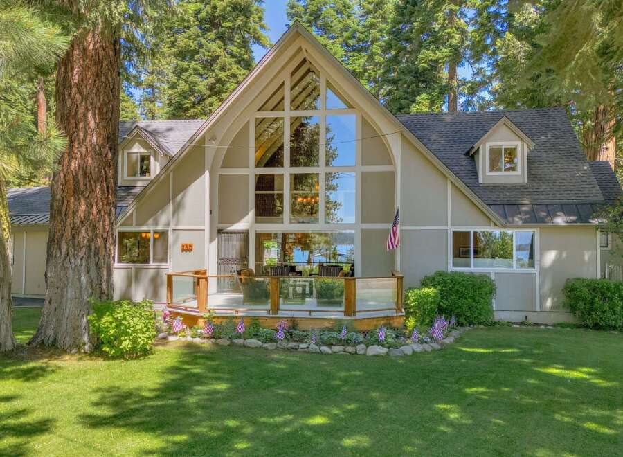 Experience breathtaking lake views from this stunning A-frame home, featuring a grand wall of windows that floods the living space with natural light.