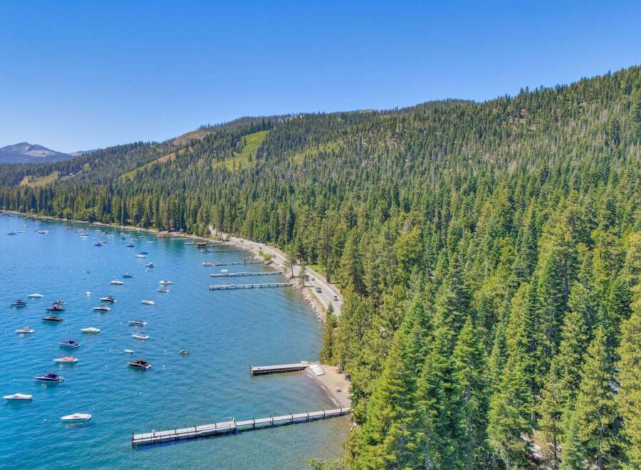 Experience the ultimate lakeside lifestyle with this stunning aerial view of a serene bay dotted with numerous boats.