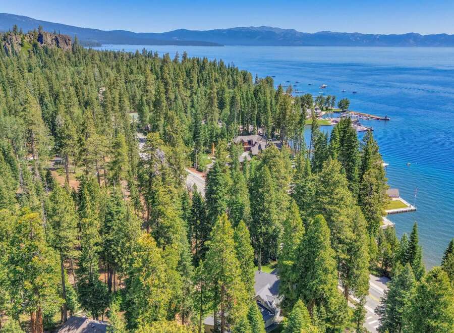 Experience luxury living with this stunning aerial view of a lakeside property nestled amidst a dense forest.