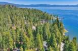 Experience luxury living with this stunning aerial view of a lakeside property nestled amidst a dense forest.