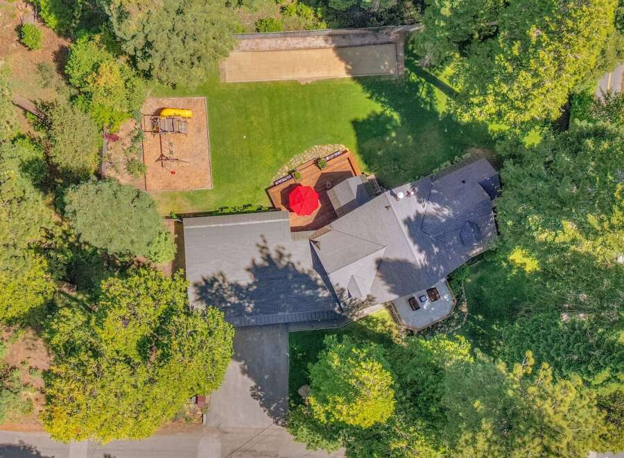 Discover this stunning property featuring a spacious backyard with a dedicated playground and a bocce ball court, perfect for outdoor recreation and family fun.