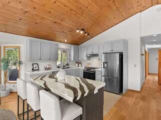 Experience the charm of this beautifully updated kitchen, featuring a striking island with a unique stone countertop and comfortable bar seating.