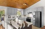 Experience modern living in this stunning kitchen, featuring sleek grey cabinetry and a striking quartz island with a unique, flowing pattern.