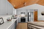 This stunning kitchen boasts sleek, light gray cabinetry complemented by a durable white quartz countertop.