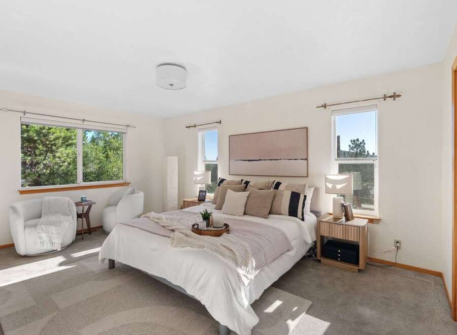 Experience serene living in this beautifully appointed bedroom, featuring a plush king-sized bed adorned with decorative pillows and a cozy throw.