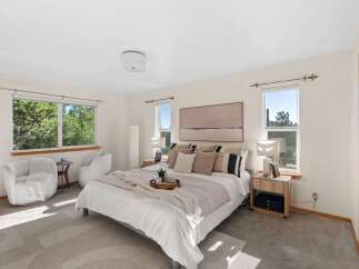 Experience serene living in this beautifully appointed bedroom, featuring a plush king-sized bed adorned with decorative pillows and a cozy throw.