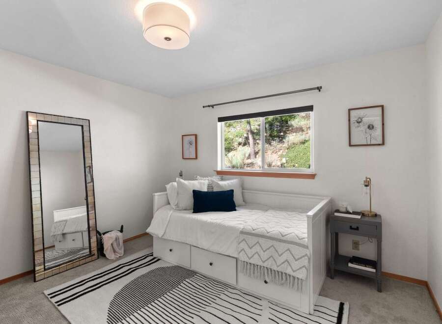 This charming bedroom features a comfortable white daybed with ample storage drawers, perfect for maximizing space.