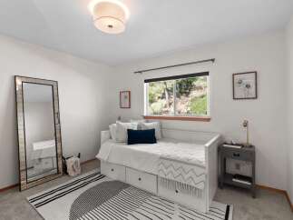 This charming bedroom features a comfortable white daybed with ample storage drawers, perfect for maximizing space.