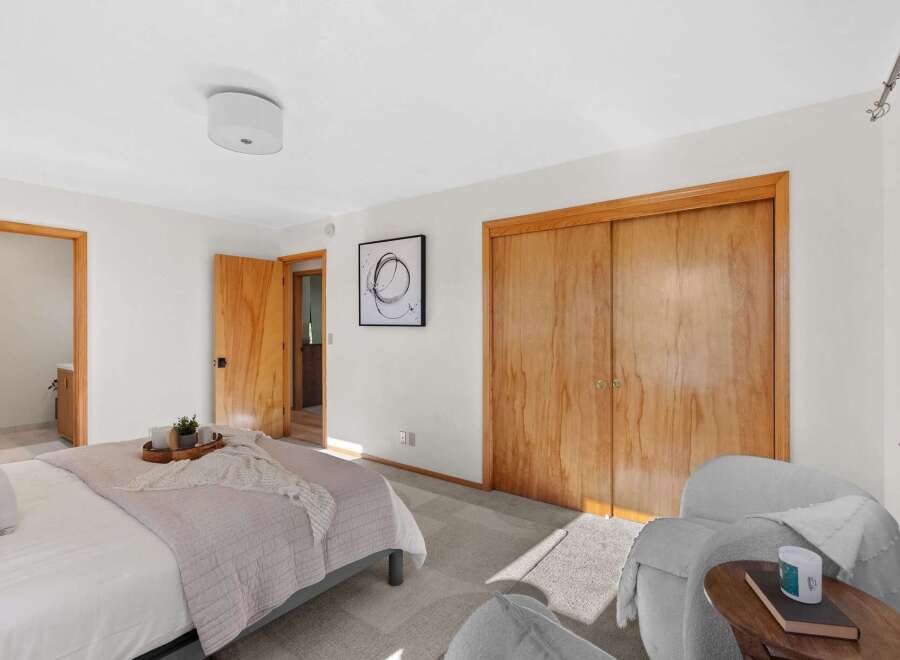 Discover comfort and style in this inviting bedroom, featuring a plush bed adorned with a soft throw and a decorative tray.