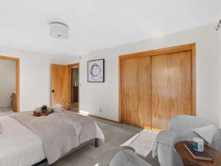 Discover comfort and style in this inviting bedroom, featuring a plush bed adorned with a soft throw and a decorative tray.