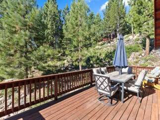 Enjoy outdoor living on this spacious wooden deck, perfect for entertaining or relaxing amidst a serene natural setting.
