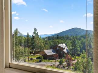 Experience serene mountain living with this stunning property nestled amidst lush evergreen forests.