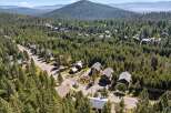 Nestled amidst a dense forest, this property offers a serene mountain retreat with multiple homes surrounded by towering pine trees.