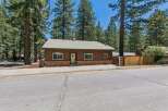 Charming single-story home nestled among tall pine trees, offering a serene and private setting.