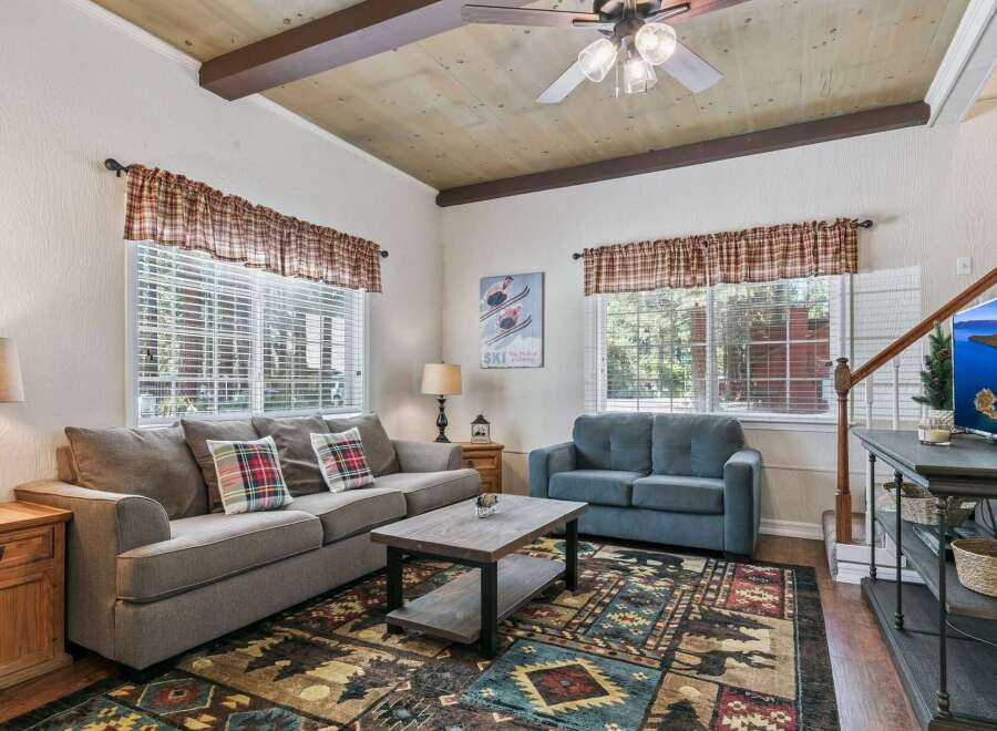 Step into this cozy living room featuring a comfortable gray sofa and a plush blue loveseat, perfect for relaxing after a day of adventure.