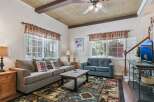 Step into this cozy living room featuring a comfortable gray sofa and a plush blue loveseat, perfect for relaxing after a day of adventure.