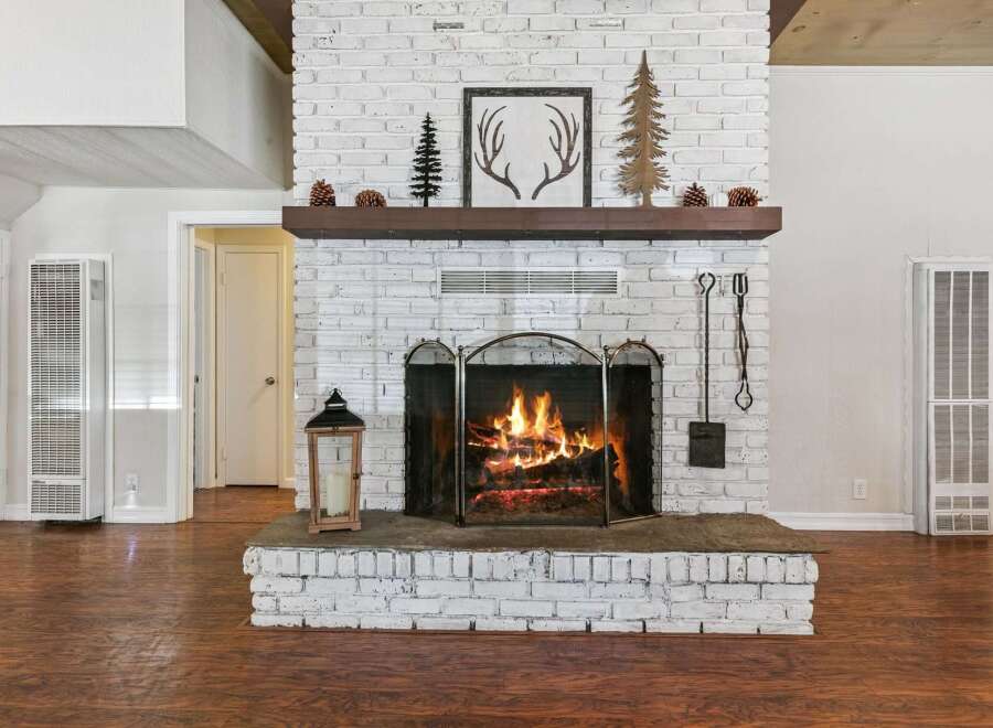 Cozy up by the crackling fireplace, a stunning focal point of this inviting living space.