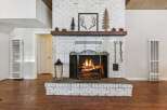 Cozy up by the crackling fireplace, a stunning focal point of this inviting living space.
