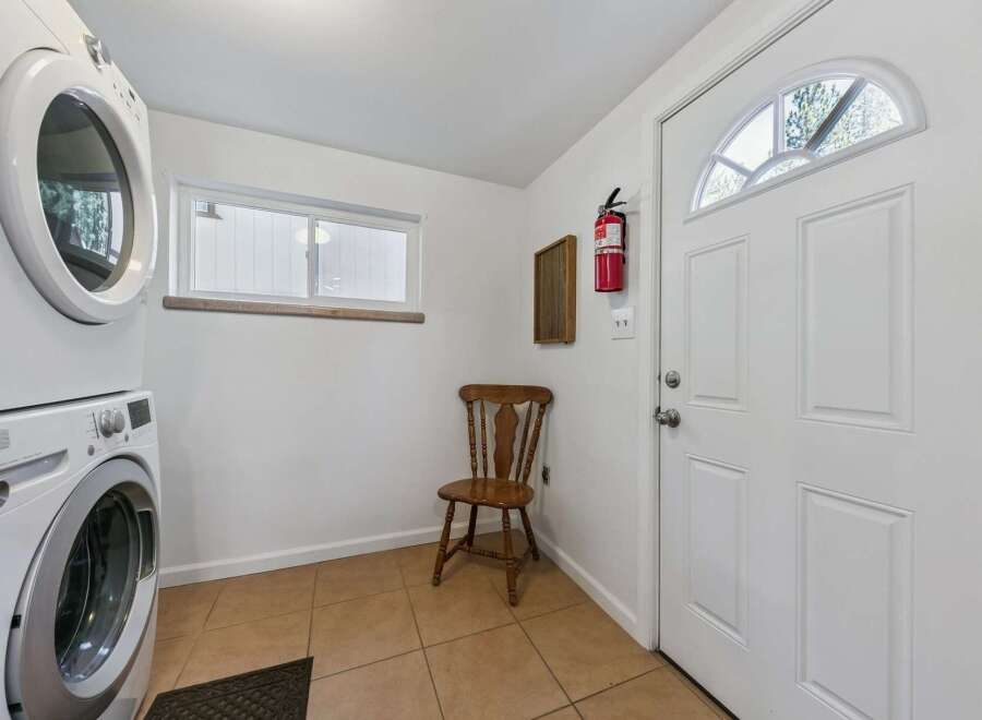 This laundry room features a stacked washer and dryer for space efficiency.
