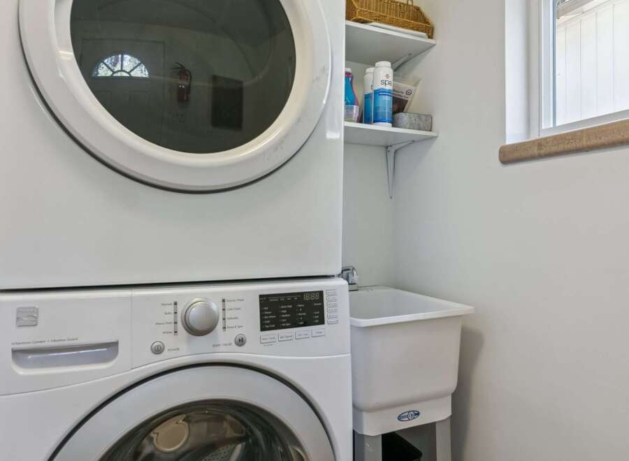 This laundry room features a stacked white washer and dryer, perfect for maximizing space in your home.