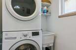 This laundry room features a stacked white washer and dryer, perfect for maximizing space in your home.