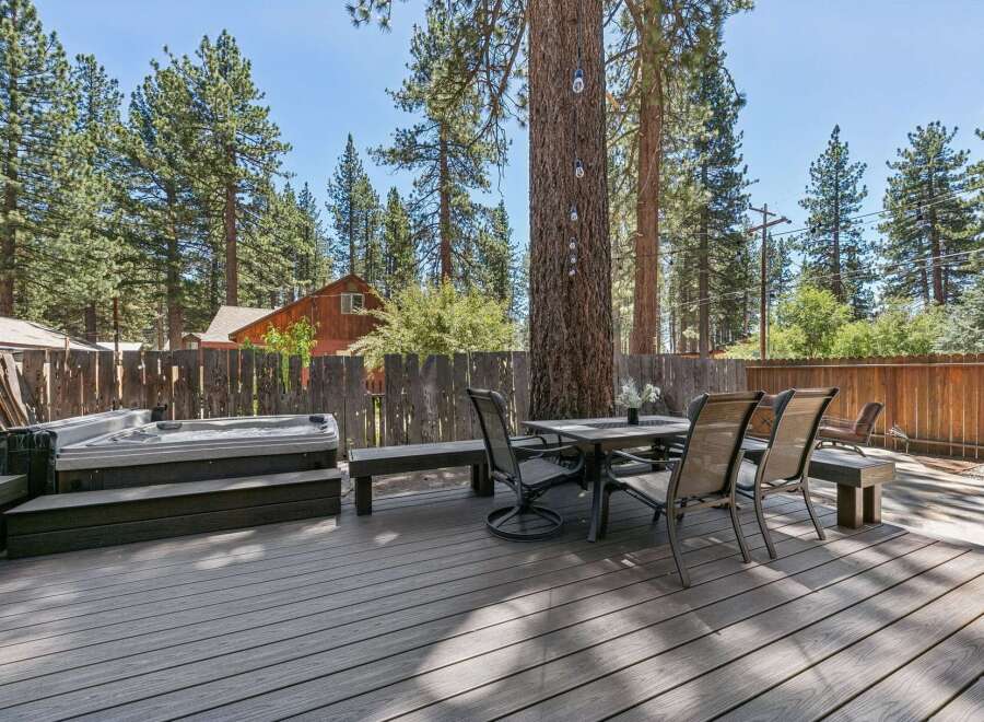 Enjoy outdoor living with this spacious deck featuring a relaxing hot tub and a dining area perfect for al fresco meals.