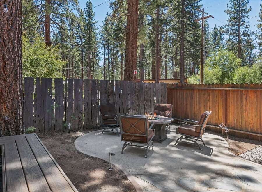 Enjoy cozy evenings in this charming backyard oasis, complete with a fire pit and comfortable seating.