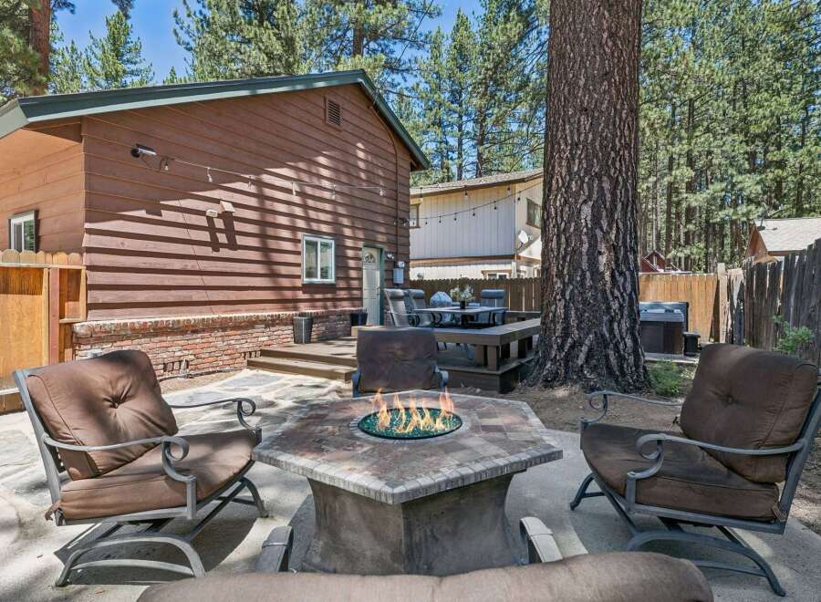 Enjoy outdoor living at its finest with this inviting backyard oasis, featuring a cozy fire pit perfect for gathering with loved ones.