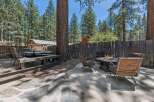 Enjoy outdoor living in this spacious backyard featuring a large deck with a dining set and a separate patio area with a fire pit and comfortable seating.
