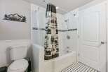 This charming bathroom features a classic white subway tile shower with a decorative black and white mosaic tile accent.