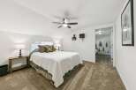 Discover this charming bedroom featuring a comfortable queen-size bed adorned with plush pillows and a cozy white quilt.