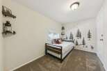 This charming bedroom features a cozy daybed with plaid pillows and a plush teddy bear, perfect for relaxation.
