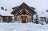 Experience the charm of this mountain retreat, featuring a rustic stone and wood facade perfect for a snowy landscape.