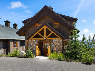 Experience rustic charm in this mountain cabin featuring a unique stone facade and warm wooden accents.