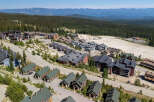 Discover this stunning mountain village featuring a collection of modern chalets and multi-story residences nestled amidst a dense evergreen forest.